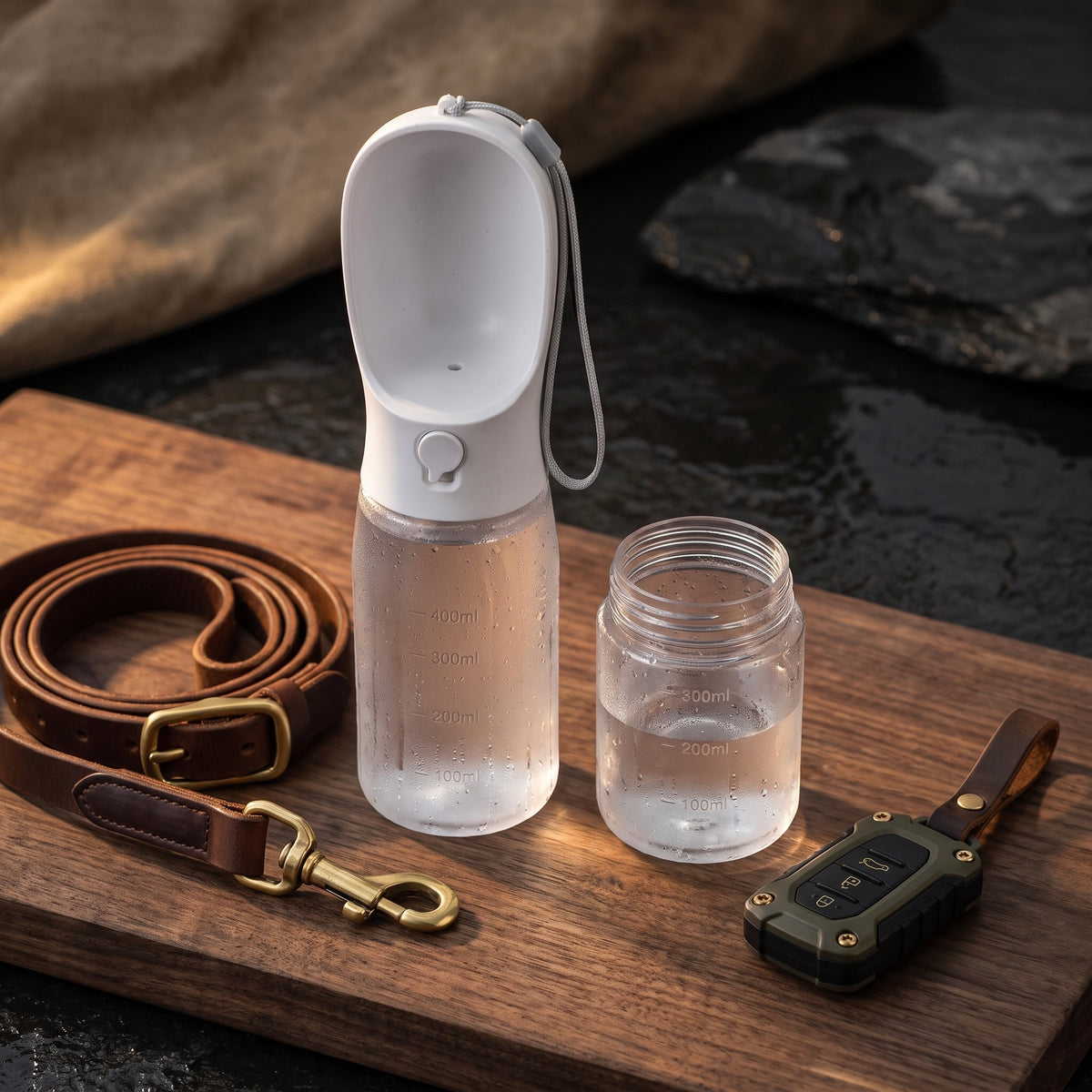 Midori portable dog water bottle next to a premium leather leash and car keys for daily walks